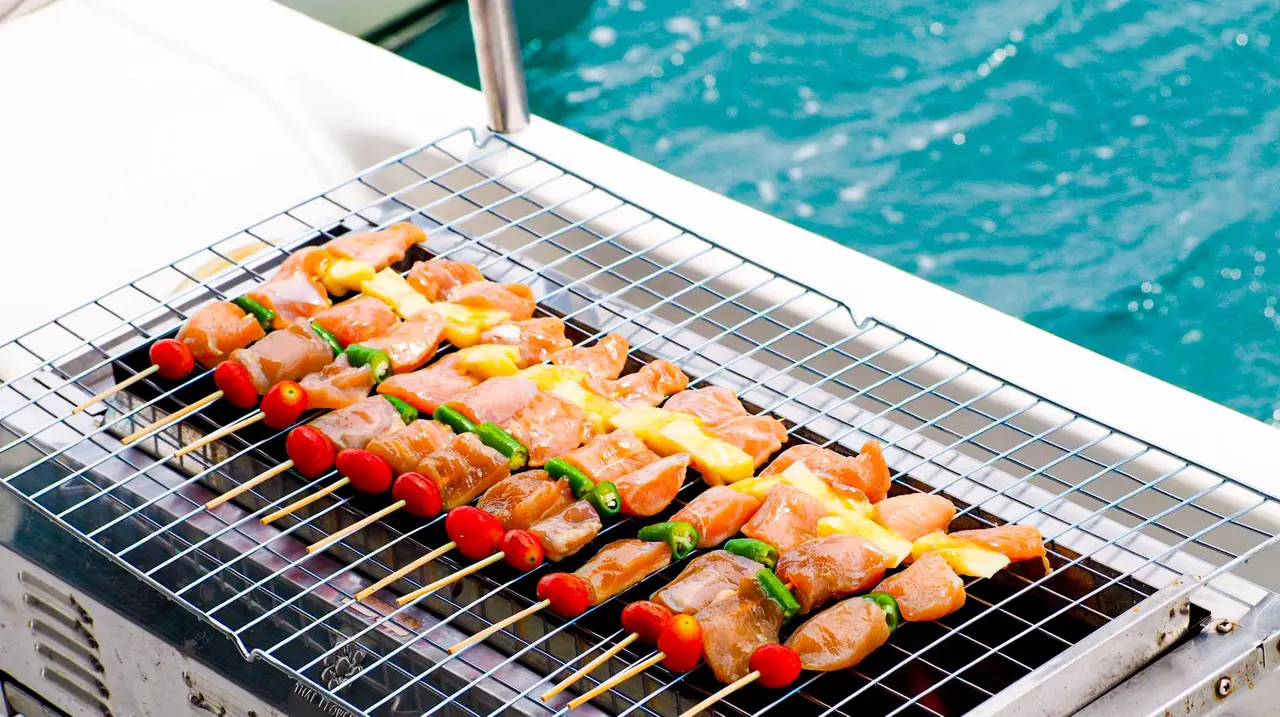 Skewers on the barbecue aboard, with the sea beyond