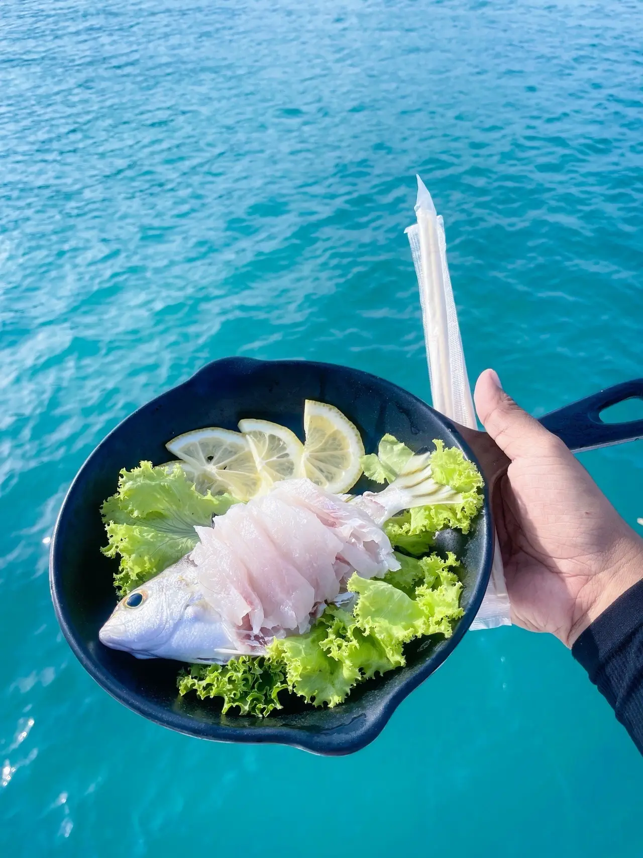 Sashimi from the day’s catch, held over the sea