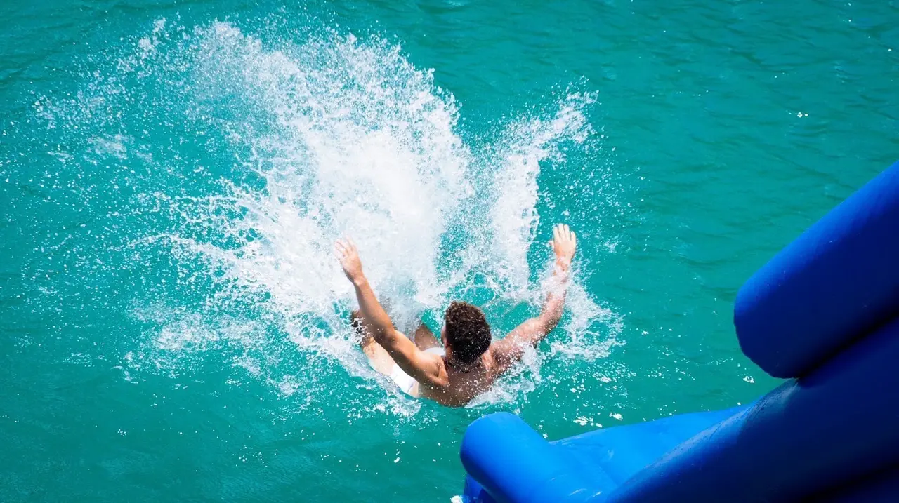 A guest hitting the water at the end of the slide