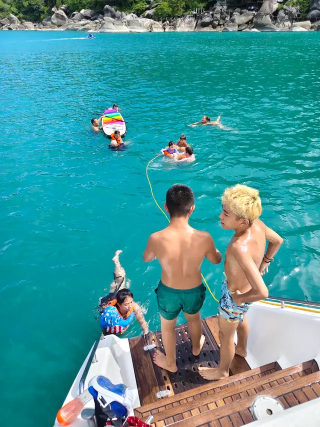 Children at the stern watching swimmers in clear water