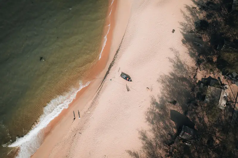 Aerial view of a secluded beach with a boat at anchor